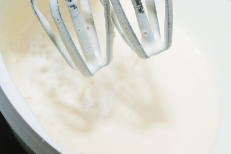 Sugar is mixed with beaten egg for dessertの写真素材