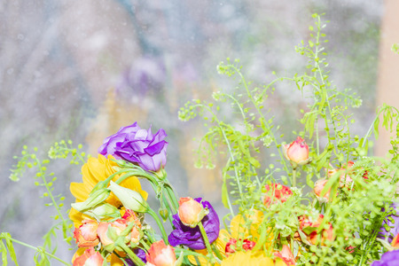 A beautiful vase of spring flowers stands on a window in a snowstorm