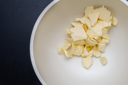 Pieces of butter are in a bowl for mixing in the preparation of cookiesの写真素材