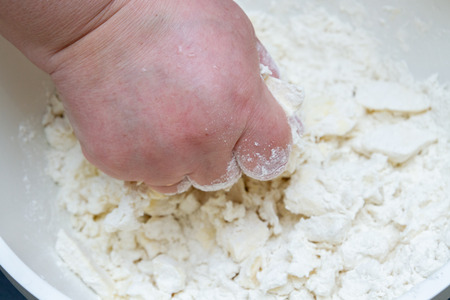 Mixing in a bowl of ingredients butter, cottage cheese and flour for the preparation of cookiesの写真素材