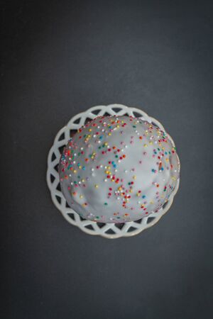 Easter spring cake in white glaze with colored sprinkles