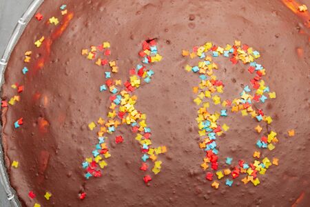 Chocolate cake at Easter with inscription of HV with colored sprinkles.の写真素材