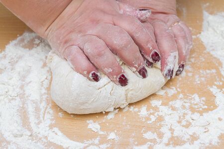 Kneading dough with flour on a wooden table at homeの写真素材