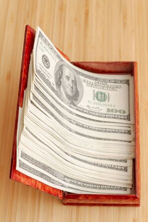 American hundred dollar bills in large quantities in a wooden boxの写真素材