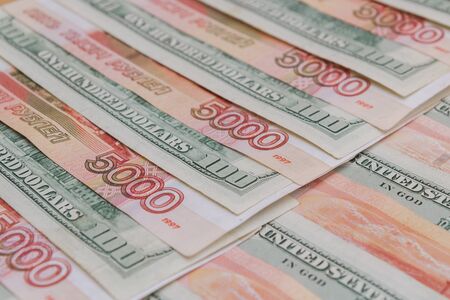 A large number of American hundred dollar bills and Russian five thousand dollar bills