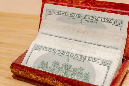American hundred dollar bills in large quantities in a wooden boxの写真素材