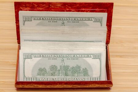 American hundred dollar bills in large quantities in a wooden box