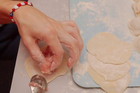 Modeling and cooking homemade dumplings woman chef at homeの写真素材