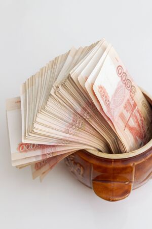 Russian banknotes of five thousand rubles in large quantities in a ceramic potの写真素材