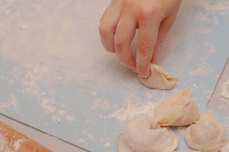 Modeling and cooking homemade dumplings woman chef at home