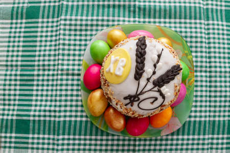 Easter cake and Easter bright colored eggs are on the plate