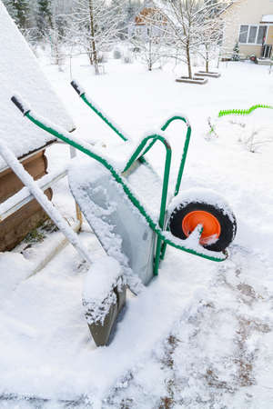 Metal garden wheelbarrow in the snow in winterの写真素材