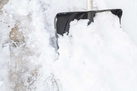 Snow cleaning with a large shovel in winterの写真素材