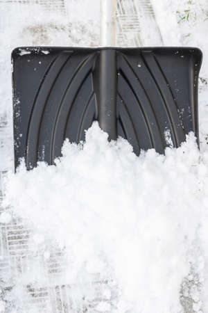 Snow cleaning with a large shovel in winter