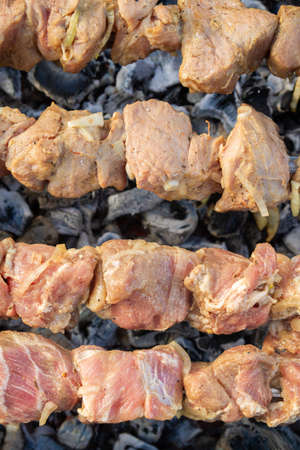 Shish Kebab made from pieces of pork is cooked on skewers on the grill