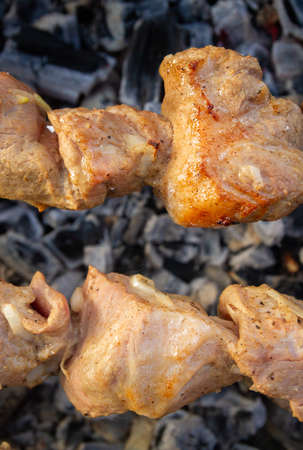 Shish Kebab made from pieces of pork is cooked on skewers on the grill