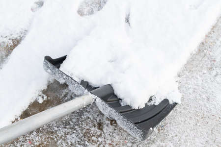 Snow cleaning with a large shovel in winterの写真素材