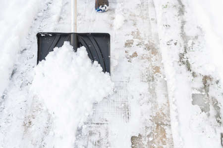 Snow cleaning with a large shovel in winter