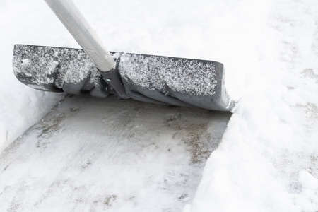 Snow cleaning with a large shovel in winterの写真素材