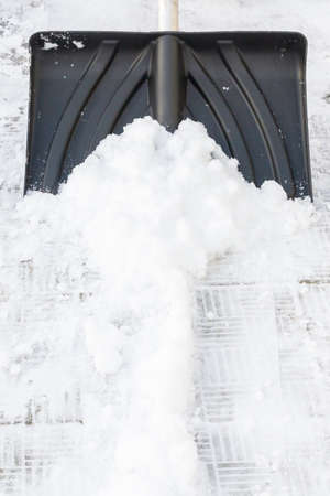 Snow cleaning with a large shovel in winterの写真素材