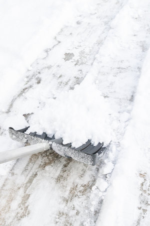 Snow cleaning with a large shovel in winterの写真素材