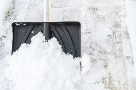 Snow cleaning with a large shovel in winter