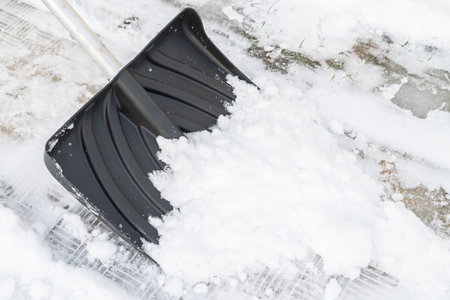 Snow cleaning with a large shovel in winterの写真素材