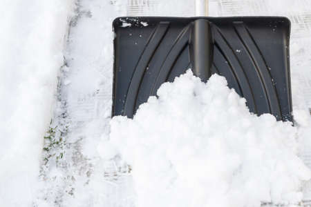 Snow cleaning with a large shovel in winterの写真素材