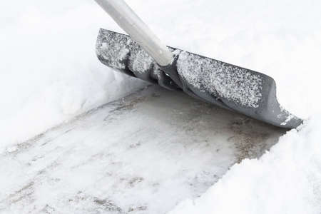 Snow cleaning with a large shovel in winterの写真素材