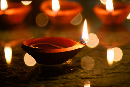 Happy Diwali - Diya lamps lit during diwali celebrationの写真素材