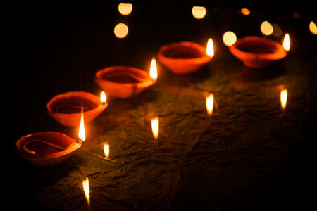 Happy Diwali - Diya lamps lit during diwali celebrationの写真素材