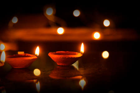 Happy Diwali - Diya lamps lit during diwali celebrationの写真素材