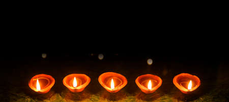 Happy Diwali - Diya lamps lit during diwali celebrationの写真素材