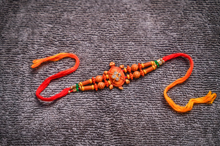 Raksha Bandhan : Rakhi on grey fabric background for Indian wrist band which is a symbol of love between Brothers and Sisters.の写真素材