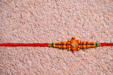 Raksha Bandhan : Rakhi with rice grains and kumkum on colorful background, Traditional Indian wrist band which is a symbol of love between Brothers and Sisters.の写真素材