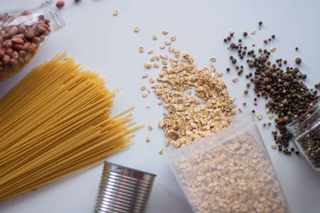 Oatmeal, macaroni and canned food on the tableの写真素材