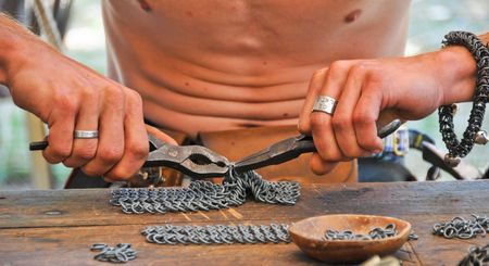 Making chain-mail with pliers from thosand ringsの写真素材