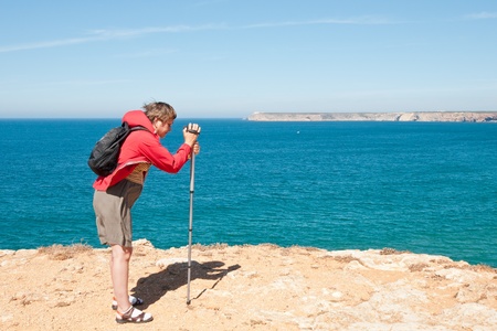 Woman filming cliffs near Sagres in Portugal during windy dayのeditorial素材