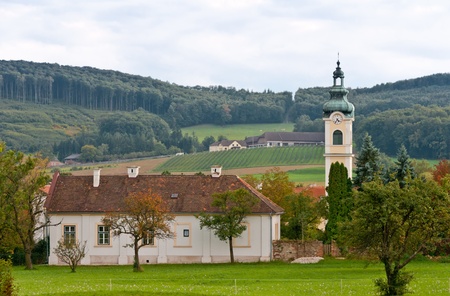 Austrian Kirche in small village with a forest and farm in the backgroundのeditorial素材