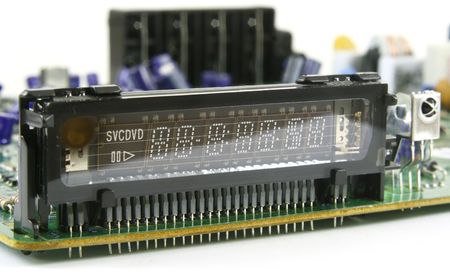 Disassembled print circuit board from DVD player with  luminescent VFD display  isolated on white.