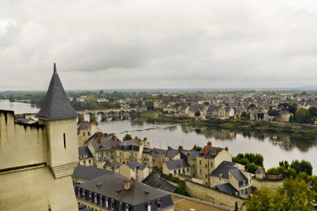 Panorama of the old French public domain standard town near the river and the forest. Tile roofs, stone bridge and narrow streets. Cloudy gray autumn day. Soft art focusの写真素材