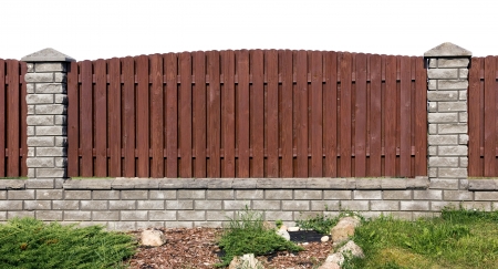 Ideal rural fence fragment  made from wooden brown  planks and gray bricks. Isolatedの写真素材
