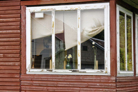 No name window of the poor rural house with daisies backgroundのeditorial素材