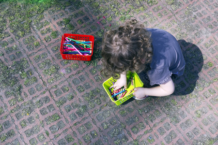 VILNIUS, LITHUANIA - APRIL, 2014: Crayon wax pastel pensils and kid in public park in April 21, 2014. In 1828 Crayon began producing   a variety of crayon and color related products.のeditorial素材