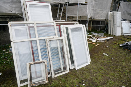 Old wooden windows are withdrawn from the building for replacement by new plastic windows