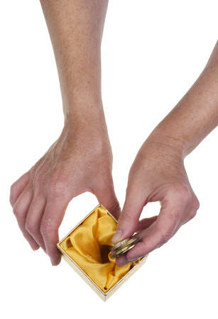 The elderly person saves up the last money for pension concept. Isolated hands and paper box studio shotの写真素材