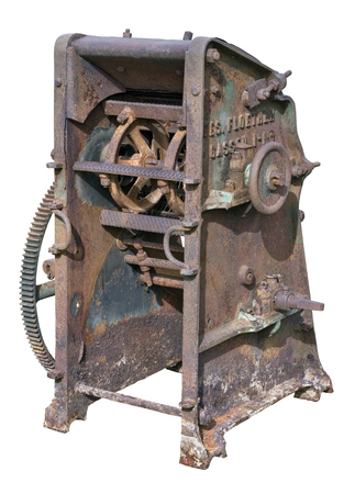Retro  vintage rusty agricultural machinery - mechanism for processing and crushing of straw. Equipment is made more than hundred years ago.  Isolated on whiteの写真素材