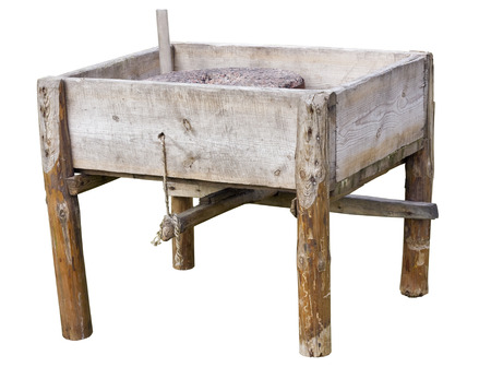 Wooden box with a granite round stone for wheat mastication in flour - a manual mill. Retro vintage...