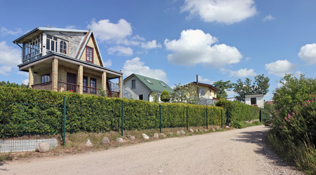 VILNIUS, LITHUANIA - JUNE 18, 2016: Summer time  and rustic style cottages behind a green fence in public garden association Kalorija near the Lithuanian village of Rastenenai. Sunny June dayのeditorial素材
