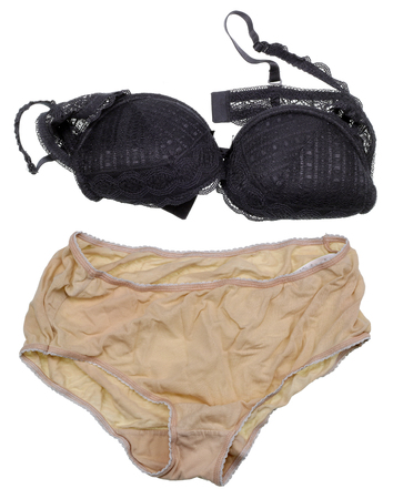 Women's silk underwear of corporal and black color -  bra  and pants. The clothes crumpled are also thrown on a floor. Mass production. Isolated on whiteの写真素材